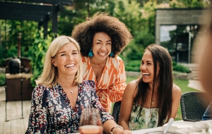 3 women in sun dresses smiling 