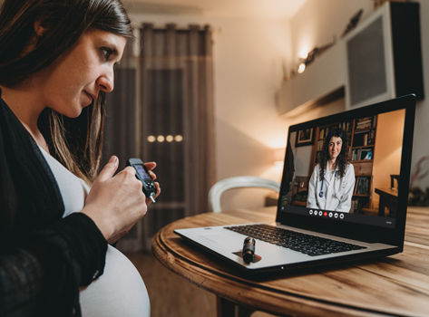 Pregnant woman speaking with her doctor via a telehealth visit.