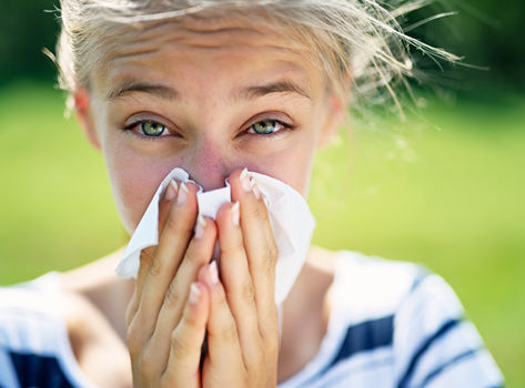 Girl with allergies using a tissue