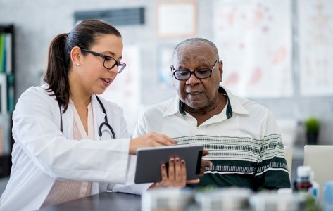 doctor shows cancer resources to patient on tablet
