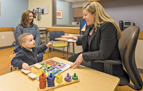 Developmental pediatrician interacts with child patient.