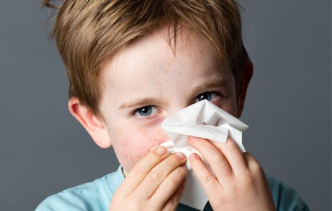 Child with allergies blows nose