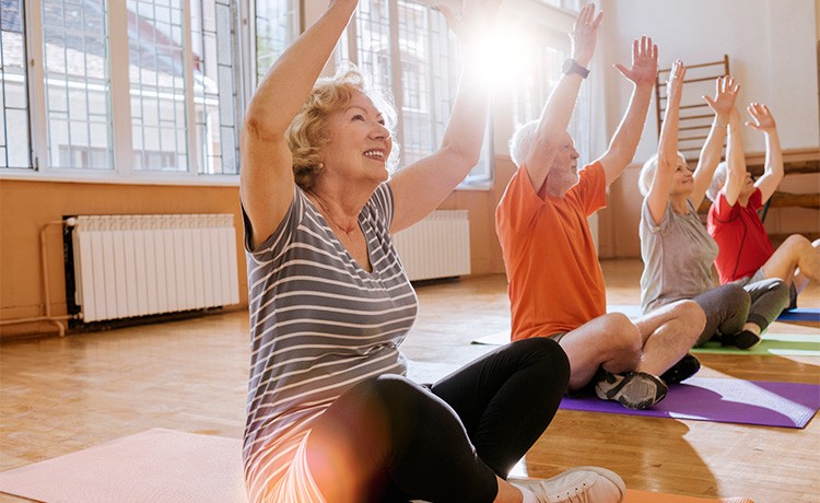 Woman lifts arms in yoga class