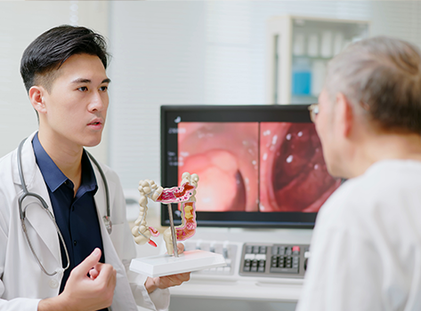 Doctor showing patient a colon anatomy model