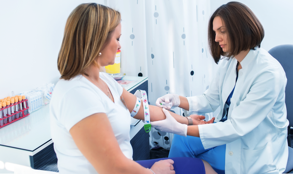 A woman receives a blood test in a lab setting.