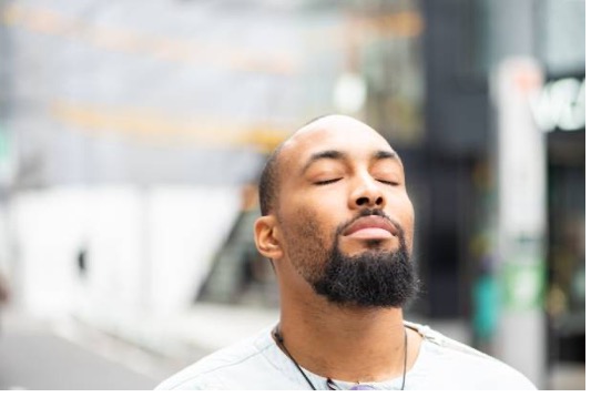 A man in a watch cap swims in cold water for the health benefits.